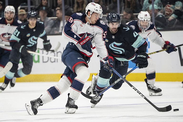 Columbus Blue Jackets forward Yegor Chinakhov (59) skates with the puck against Seattle Kraken defenseman Justin Schultz