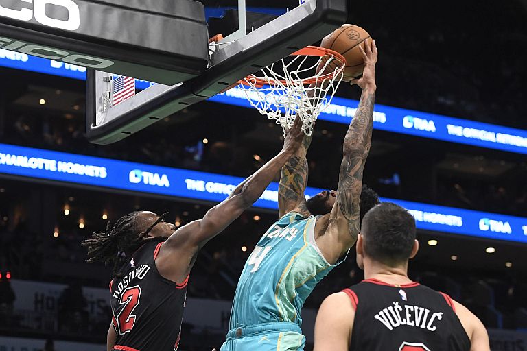 Charlotte Hornets center Nick Richards (4) dunks through the defense of Chicago Bulls guard Aye Dosunmu (12)