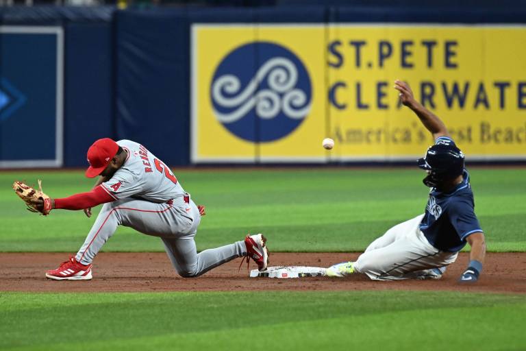 The Tampa Bay Rays' Amen Rosario slides into second base as the Los Angeles Angels' Luis Rengifo attempts to catch the ball